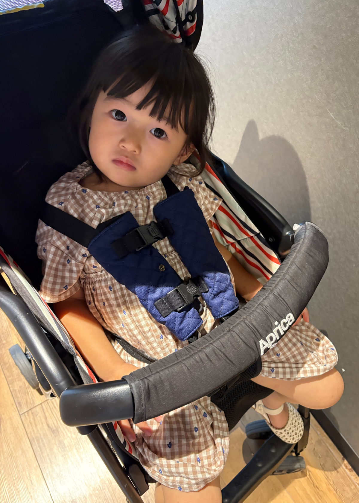 チャイルドシート抜け出し防止ベルトの使用シーン、車内で子どもがベルトを着用している様子