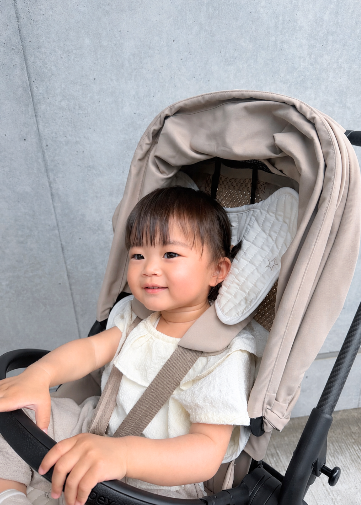 ベビーカーシート薄手タイプをベビーカーに装着して赤ちゃんが座っている使用イメージ。後頭部と背中を支える形状