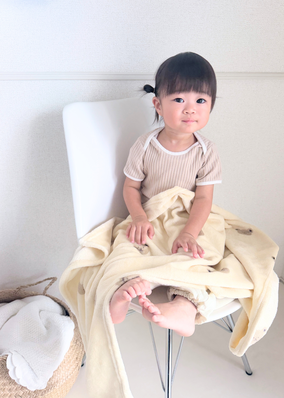 フランネルブランケットを膝に掛けて座る子ども、室内での使用イメージ