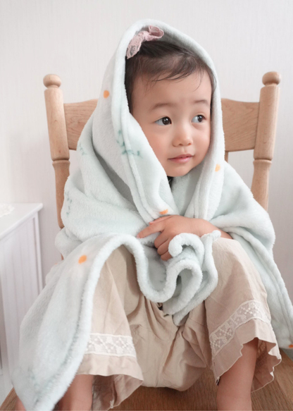 フランネルブランケットを頭から羽織る子ども、軽くて柔らかなブランケットの使用例
