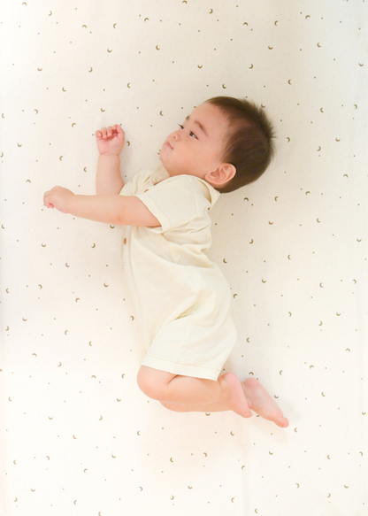 ベビーキッズ防水シーツの上で赤ちゃんが眠っている使用イメージ。通気性のある6重ガーゼ素材