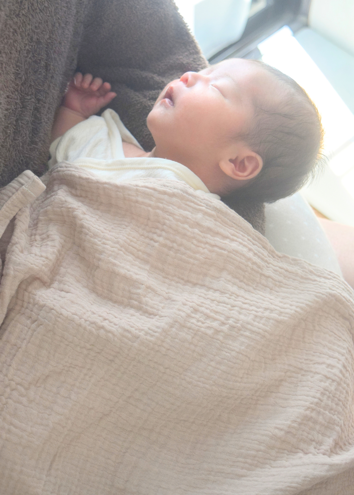 赤ちゃんを授乳ケープで包みながら横になって授乳している使用イメージ。綿100％ダブルガーゼのやわらかな素材