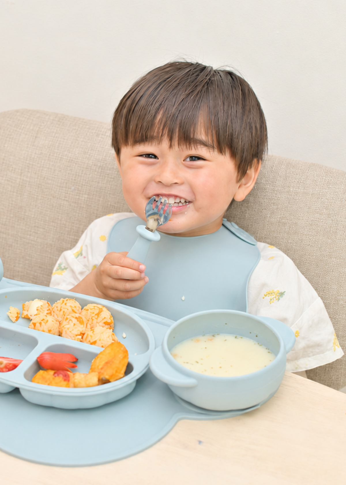 男の子がスプーンとフォークで食事をしている使用イメージ。シリコン製の太めの持ち手を握っている様子