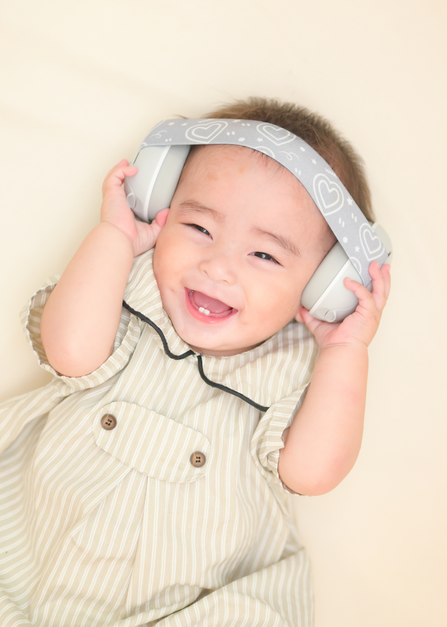 ベビータイプの防音イヤーマフを赤ちゃんが着用している使用イメージ。ベージュ系の衣服と合わせた着用例
