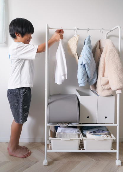 子どもがキッズハンガーラックに洋服を掛けている使用イメージ。自分で片付けやすい高さ設計