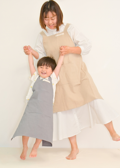 母親と子どもがベージュ系のエプロンをお揃いで着用している使用イメージ。親子リンクコーデ