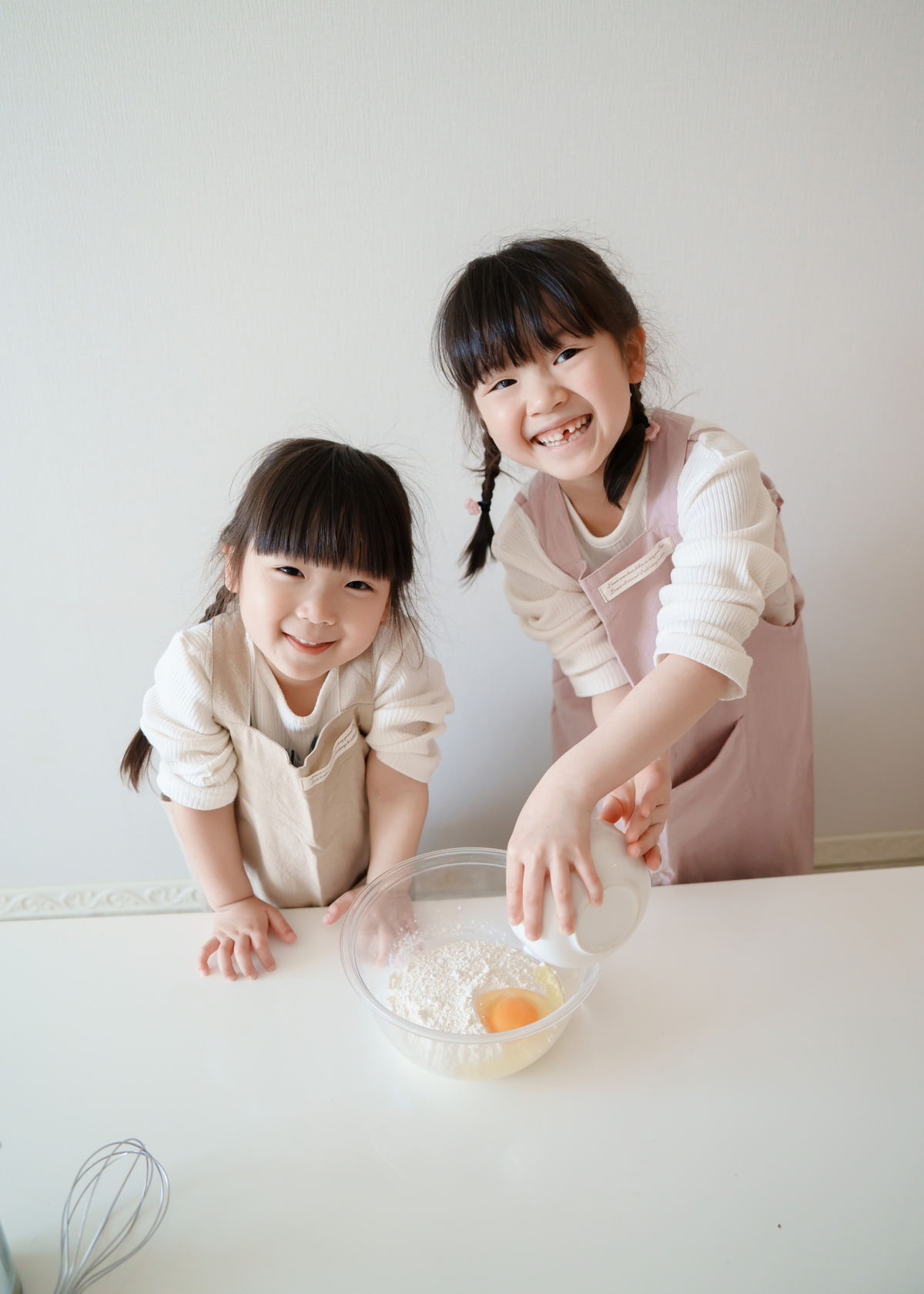 母親と子どもがエプロンを着用して料理をしている使用イメージ。親子で料理を楽しむリンクコーデ