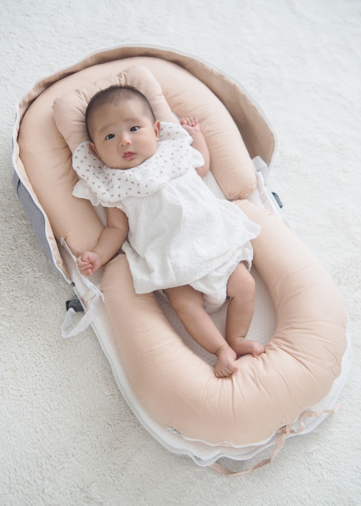 ベッドインベッドで眠る赤ちゃんの使用イメージ、周囲をクッションで囲んだベビー用寝床
