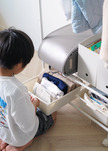 キッズハンガーラックの収納ボックスから衣類を取り出す子どもの使用イメージ