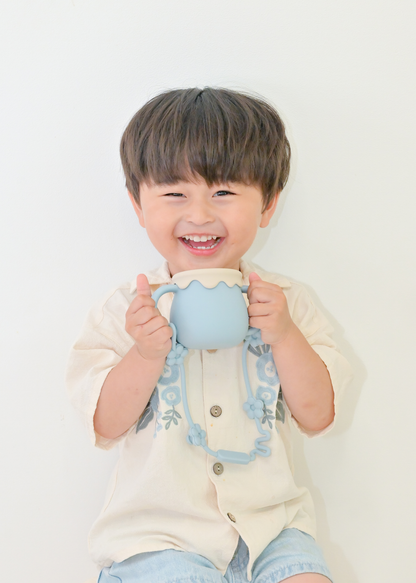 ブルーの3WAYマグを子どもが両手で持っている飲用イメージ。ストローマグとして使用