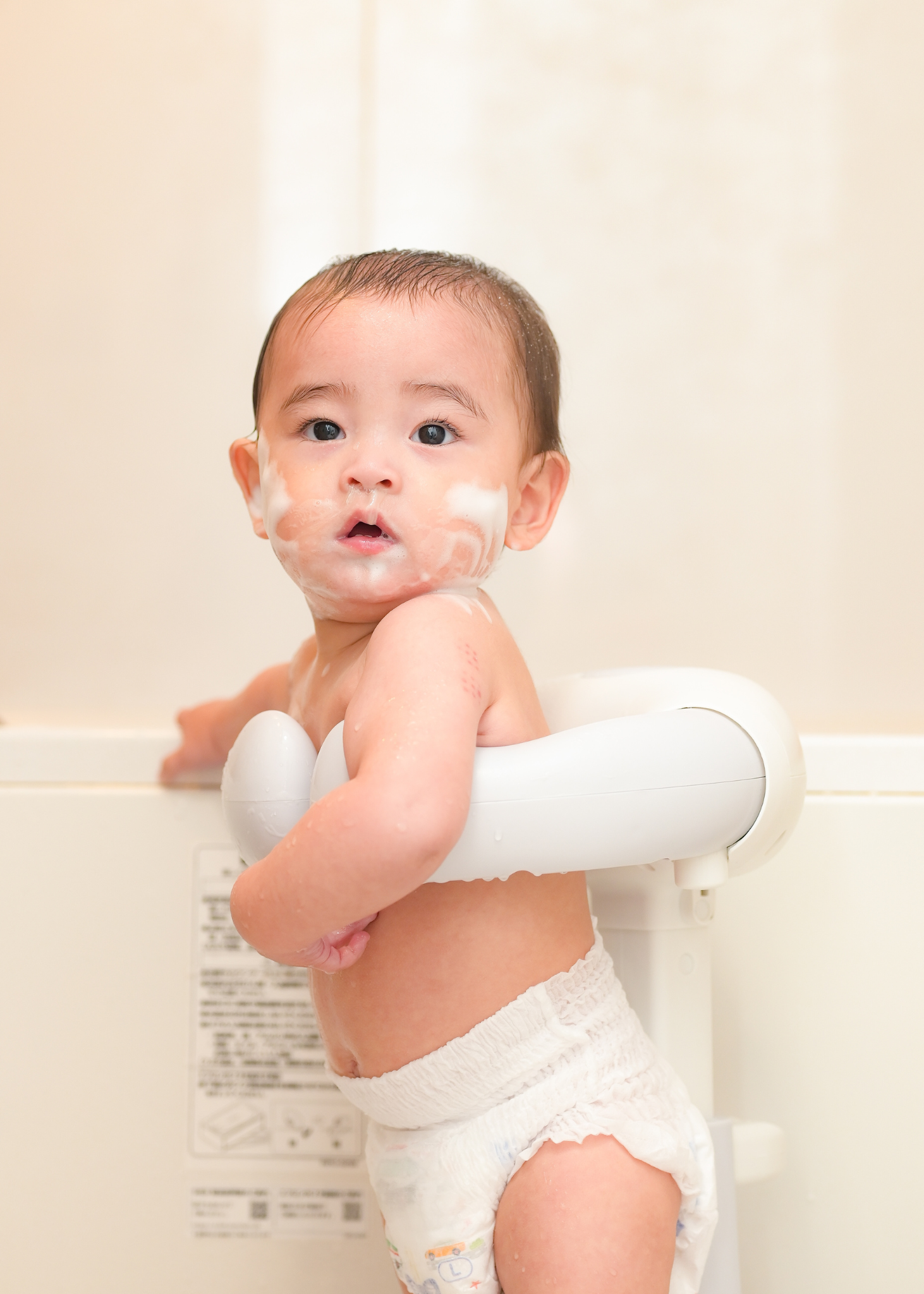 赤ちゃんがベビーシャワースタンドに座って後ろを振り向いている使用イメージ