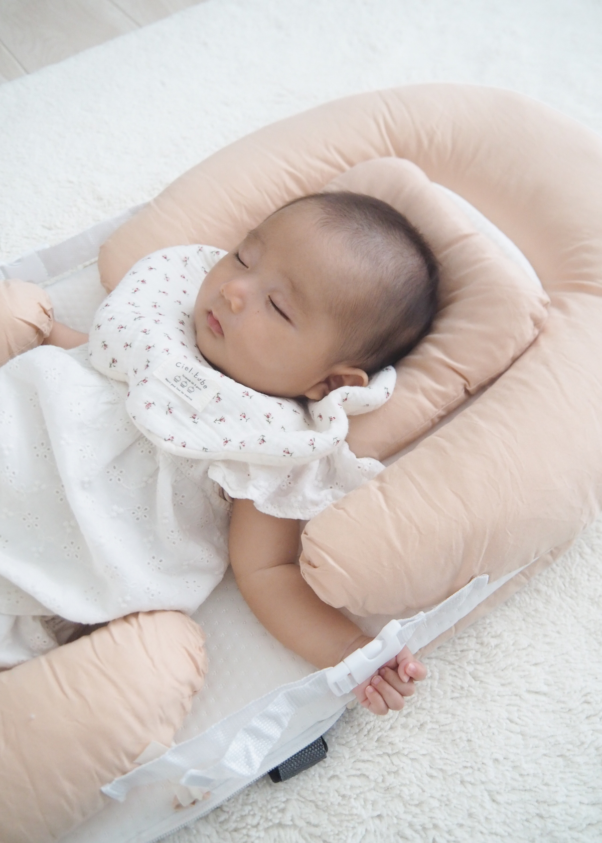 ベッドインベッドで仰向けに寝る赤ちゃん、寝床の広さとクッション形状の使用イメージ