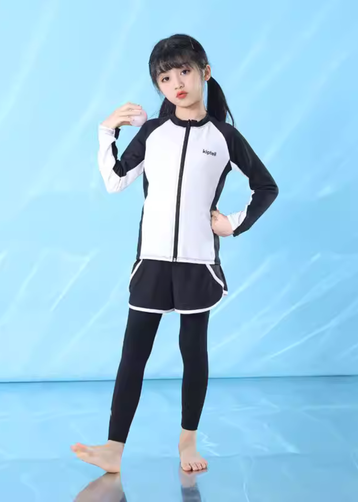 女の子がキッズ水着3点セットを着用してプールで遊んでいる使用イメージ。全身をカバーする長袖トップスとレギンス