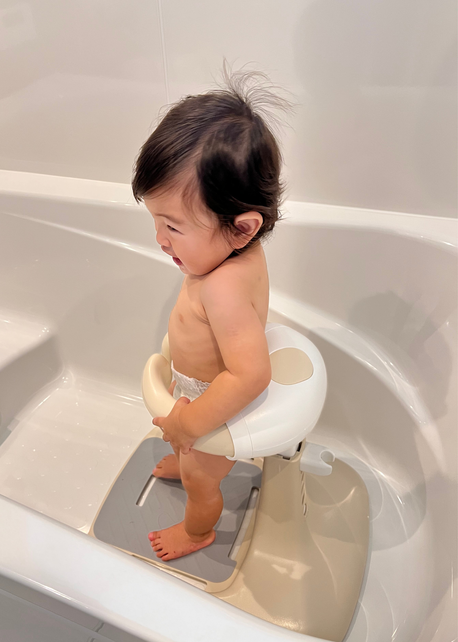浴槽内で赤ちゃんがベビーシャワースタンドに座っている使用イメージ。入浴時の姿勢をサポート