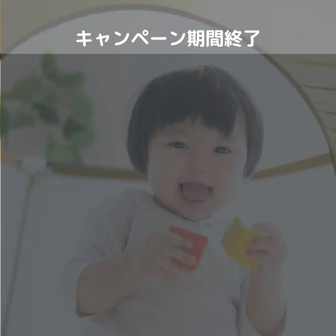 笑顔の赤ちゃんが色とりどりのおもちゃブロックを二つ持っている。