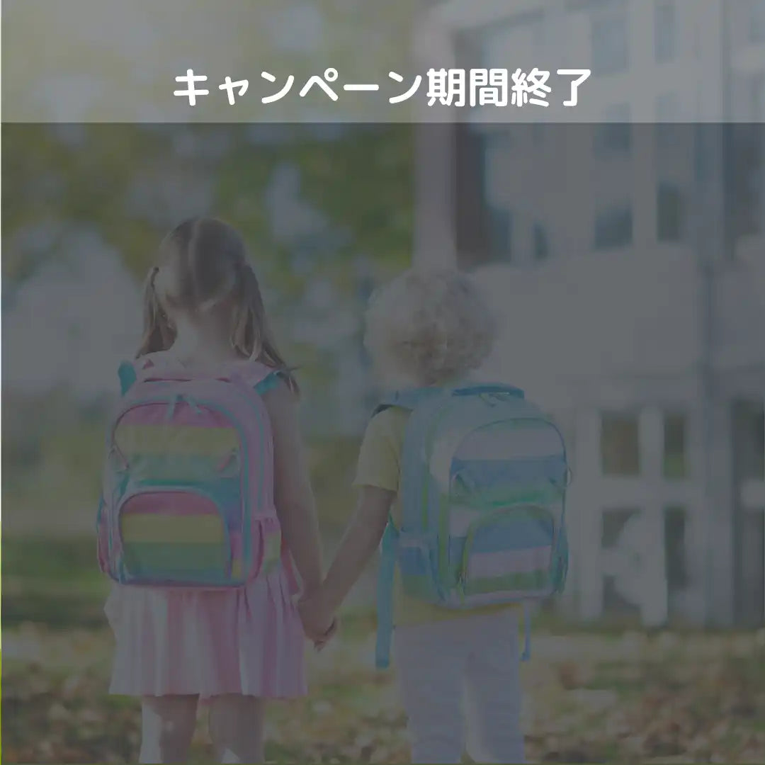 リュックを背負って手をつないでいる二人の子どもたち。