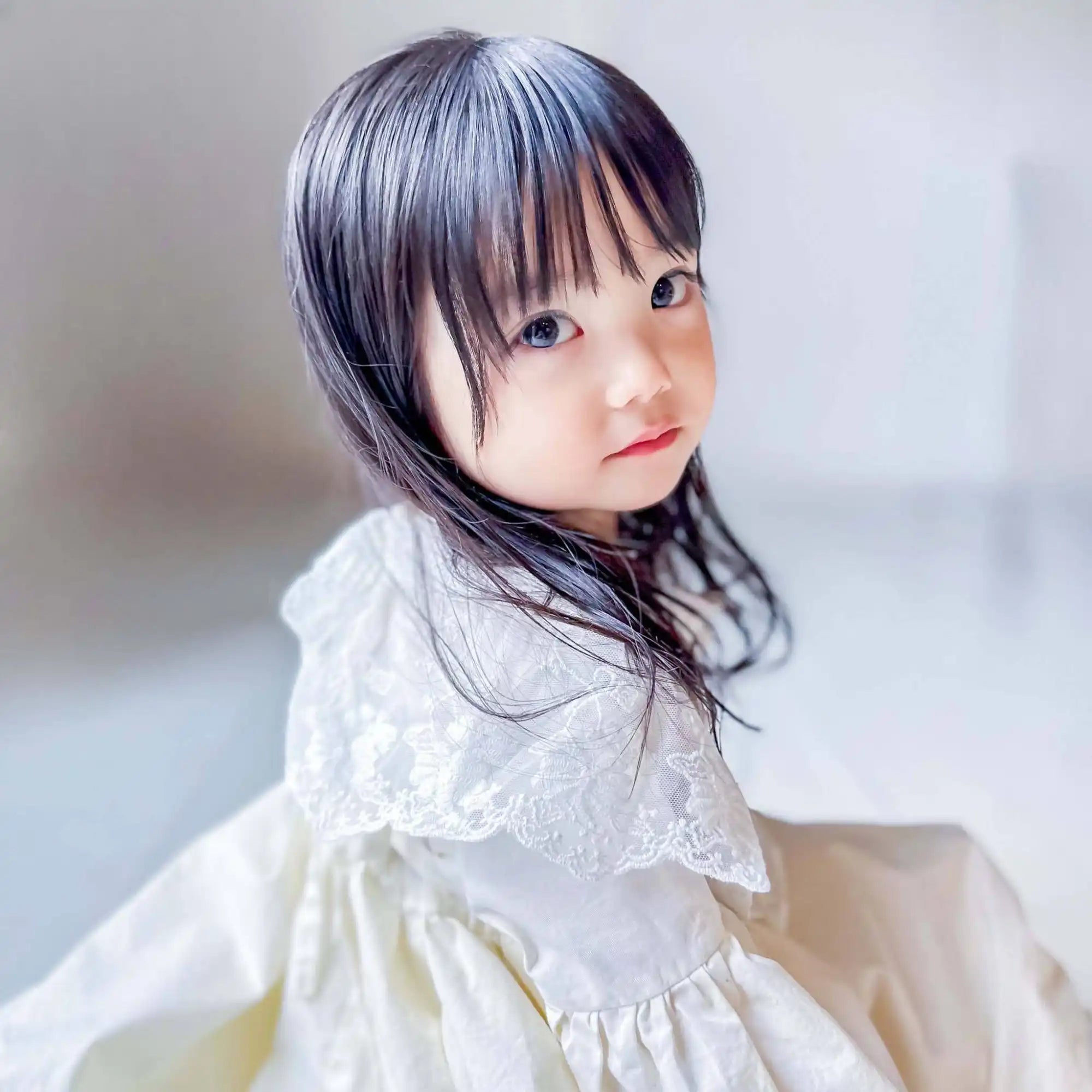 レース襟の白いドレスを着た若い少女。